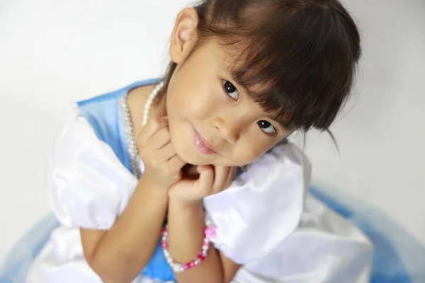 4岁的日本女孩，身穿连衣裙，双手托着下巴) — 图库照片