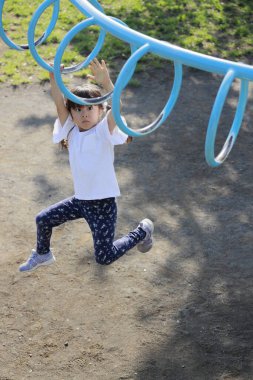 Japon kız maymun parmaklıklarıyla oynuyor (5 yaşında))