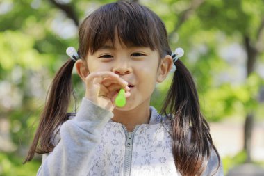 Japon kız yeşil baloncukla oynuyor (5 yaşında))