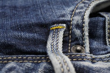 Sarı dikişli, yalıtılmış mavi günlük kot pantolon cebine yakın makro (kemer düğümüne odaklan)