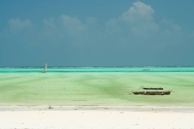 Panoramik sonsuzluk manzarası turkuaz yeşil sudaki beyaz kum üzerinde geleneksel ahşap yelkenli tekneler - Paje plajı, Zanzibar