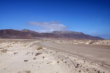 Fuerteventura, Kanarya Adaları 'nın kurak arazisi boyunca kuzeybatı kıyısı boyunca uzanan toprak yol.