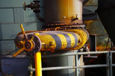 Landschaftspark Duisburg, Almanya: İzole edilmiş siyah ve sarı şeritli eski paslı kontrol kapakçığı