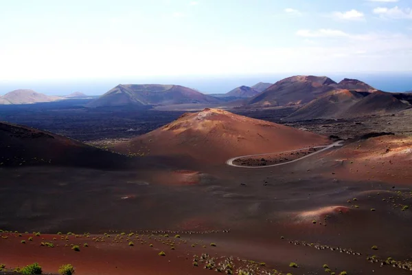 火山の円錐形の上の無限のシュールな谷とぼやけた地平線のクレーターの上のパノラマビュー Timanfaya Lanzarote Canary Islands — ストック写真
