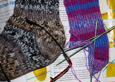 Viersen, Almanya - 13 Ekim. 2019: Alman dergisinde örülmüş iki çorabı örgü eğitimi, örgü iğnesi ve okuma gözlüğü ile kapatın