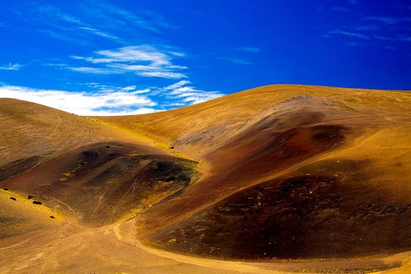 位于智利阿塔卡马沙漠的科皮亚波山脉 与蓝天和白云形成对比的五彩斑斓的红 黑荒山山脊上的景色 — 图库照片