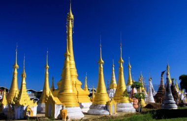INLE Gölü (İNDEIN KÖLÜ), MYANMAR - 23 ARALIK. 2015: Mavi gökyüzüne karşı bir sırada altın şapşalların görüntüsü