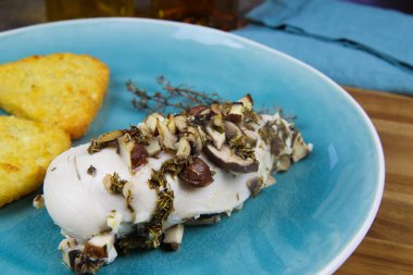 Buharda pişirilmiş tavuk göğsünü kekik otlarıyla, şampiyon mantarlarıyla ve kızarmış patateslerle kaplayın.