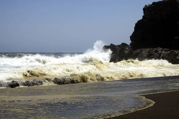 Яскраві Хвилі Вдаряються Камінь Розбризкують Воду Повітрі Віддаленому Піщаному Піщаному — стокове фото