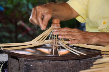 Yaşlı sıska eller Chiang Mai 'de kağıt şemsiyeler için çerçeve üretiyor.