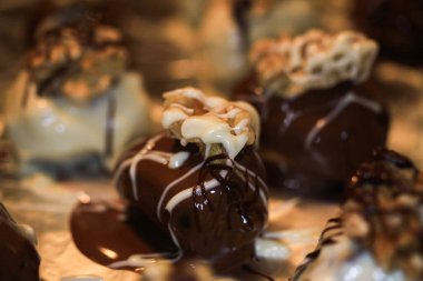 Kurutmak için tepsiye alüminyum folyoyla serpiştirilmiş ve içi hurma dolu taze ev yapımı beyaz ve kahverengi cevizli pralineler koyun.