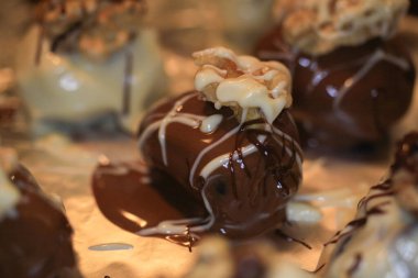 Kurutmak için tepsiye alüminyum folyoyla serpiştirilmiş ve içi hurma dolu taze ev yapımı beyaz ve kahverengi cevizli pralineler koyun.