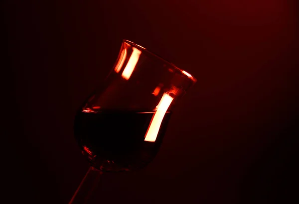 独立した光沢のあるチューリップ酒のスタジオ写真赤い光に照らされたシェリーガラス 左側のガラス縁に焦点を当てる — ストック写真