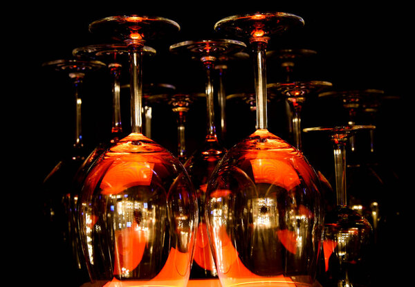 View on group of isolated red yellow shiny glowing wine glasses in cupboard