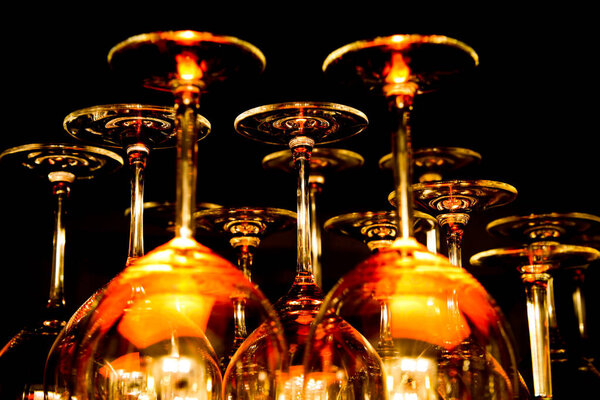 View on group of isolated red yellow shiny glowing wine glasses in cupboard