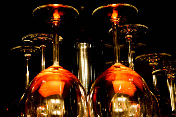View on group of isolated red yellow shiny glowing wine glasses in cupboard