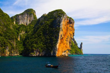 Dik kırmızı kaya duvar sudan mavi gökyüzüne yükseliyor tropik ada Ko Phi Phi, Andaman denizi, Tayland