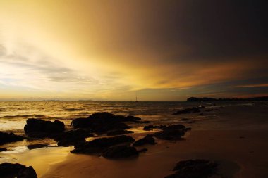 Şiddetli yağmurdan sonra gün batımı. Arcus raf bulutları ve taşlarla okyanusta tropikal ada Ko Lanta, Tayland