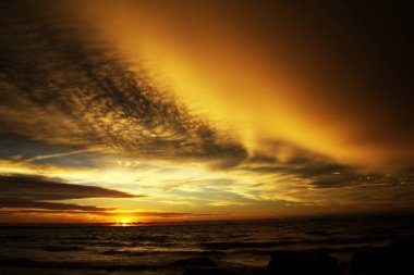 Şiddetli yağmurdan sonra gün batımı. Arcus raf bulutları ve taşlarla okyanusta tropikal ada Ko Lanta, Tayland
