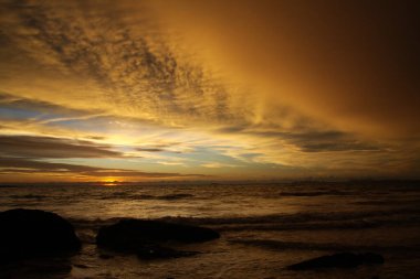 Şiddetli yağmurdan sonra gün batımı. Arcus raf bulutları ve taşlarla okyanusta tropikal ada Ko Lanta, Tayland