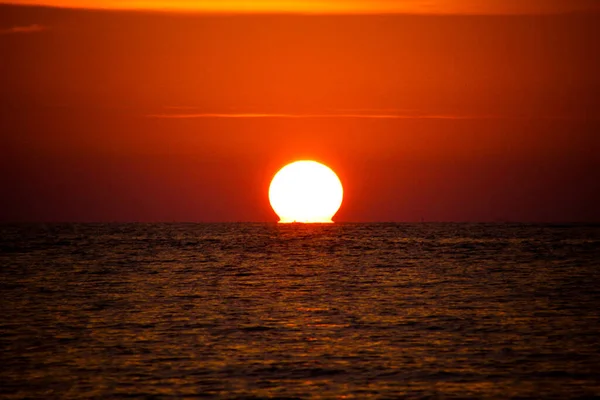 タイのプーケット島の海の地平線に溶けオレンジ色の赤い輝く明るい丸い太陽のボール — ストック写真