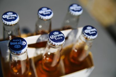 Viersen, Almanya - 25 Nisan. 2020: Karton kutuda taç kapakları olan izole edilmiş sarı Meksika Corona şişelerini kapatın