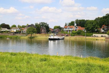 Kessel, Hollanda - 16 Mayıs. 2020: Beesel 'den yeşil tarım arazisi, Maas nehri ve feribot manzarası