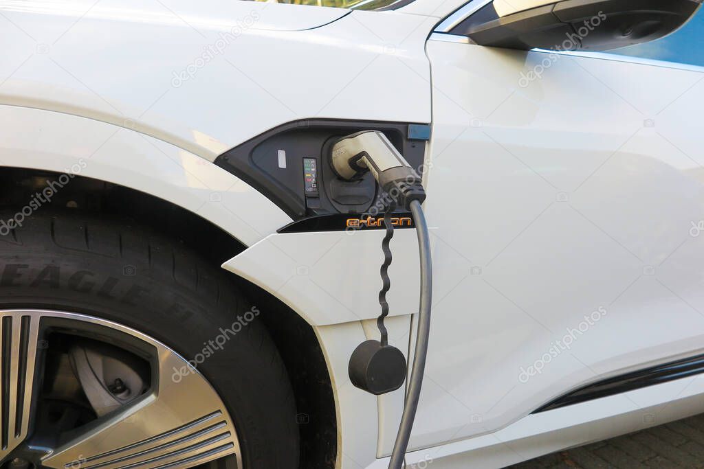 Viersen, Germany - October 30. 2019: Close up of isolated plug connector charging battery of electric car Audi e-tronic