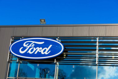 Dinslaken, Almanya - 18 Aralık. 2019: Amerikan otomobil üreticisi Ford 'un izole edilmiş mavi gümüş logosu araba satıcısının girişinde bulutsuz mavi gökyüzüne karşı