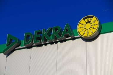 Dinslaken, Almanya - 18 Aralık. 2019: Çatıdaki bulutsuz mavi gökyüzüne karşı Alman denetleme firması Dekra 'nın yeşil logosu ve harfi
