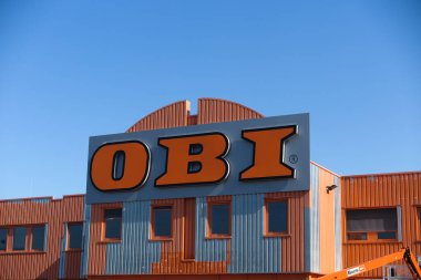 Kaldenkirchen, Almanya - 4 Nisan. 2020: Alman Obi inşaat mağazasının girişindeki mavi gökyüzüne karşı park yeri