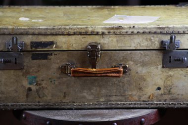 Perçin, deri tutuş ve kombinasyon kilitleri olan izole edilmiş eski bavulu kapat.