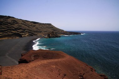 Farklı renklerde, engebeli kayalıklarla çevrili tenha bir göle bakın. El Golfo, Lanzarote.