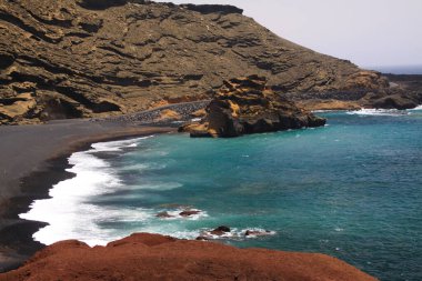 Farklı renklerde, engebeli kayalıklarla çevrili tenha bir göle bakın. El Golfo, Lanzarote.