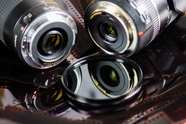 負のフィルムストリップ上の絶縁円形フィルタを持つ2つのカメラレンズの閉じる — ストック写真