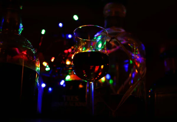 ラム酒と隔離されたショットガラスの低角度ビュー 鮮やかな色とぼやけたボトルの背景を持つボケ — ストック写真