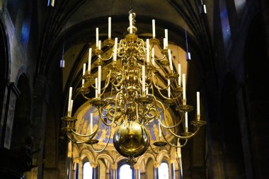 Maastricht, Hollanda - 30 Kasım. 2019: Roma Katolik Kilisesi 'nin (Basiliek van Onze-Lieve-Vrouw-Tenhemelopneming) kubbesinin altında mumlarla altın avizeye alçak görüş)