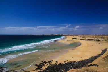 Dik yamaçtaki (El Cotillo) beyaz köydeki (Playa del Aljibe) yeşil okyanuslu kum tepelerine bakın - Kuzey Fuerteventura