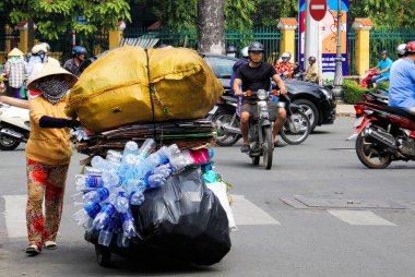 HO CHI MINH ŞEHRİ, VİETNAM - 28 ARALIK. 2014: Saigon trafiğinde aşırı yüklü ve plastik şişe toplayan motosiklet