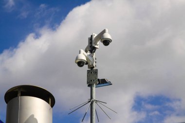 Daha iyi güvenlik için mavi gökyüzü ve Venlo şehir merkezindeki bulutlara karşı güvenlik kameralarının düşük açılı görüntüsü