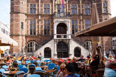 VENLO, NEtherlands - 8 AĞUSTOS. 2019: Belediye binasının önündeki meydanda insanlar kafelerin önünde oturuyor