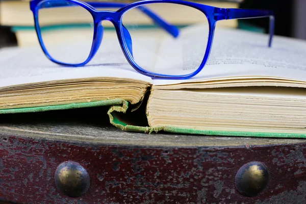 Pohled Starou Zažloutlou Knihu Modrými Brýlemi Čtení Starožitném Dřevěném Stole — Stock fotografie