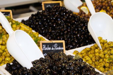 Tecrit edilmiş yeşil ve siyah Fransız zeytinlerinin yakınından çiftçi pazarındaki Provence 'den baharatlı bitkiler - St. Tropez, Fransa