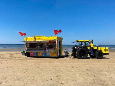 Zandvoort, Hollanda - 26 Haziran. 2020: Sarı römorklu traktörün görüntüsü yazın Hollanda 'nın kuzey sahilinde abur cubur ve içecek satıyor