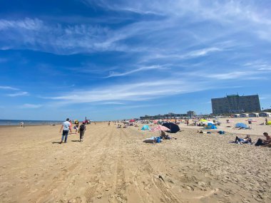 Zandvoort, Hollanda - 26 Haziran. 2020: Kum kumsalında şemsiyelerle Kuzey Denizi 'nde mavi gökyüzü ve çok az sirrus bulutuyla birlikte
