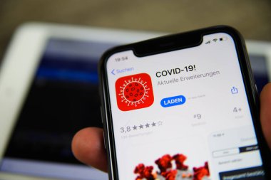 Viersen, Almanya - 30 Haziran. 2020: Cep telefonu ekranının kapatılması: İndirme mağazasından covid-19 uyarı uygulaması (kırmızı sembole odaklan)