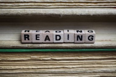 İzole edilmiş antika eski kitap yığını metin blokları ve ahşap alfabe küpleriyle dolu sarı sayfalar.