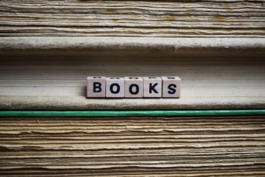 İzole edilmiş antika eski kitap yığını metin blokları ve ahşap alfabe küpleri ile sararmış sayfalar kelime kitapları oluşturur.