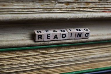 İzole edilmiş antika eski kitap yığını metin blokları ve ahşap alfabe küpleriyle dolu sarı sayfalar.