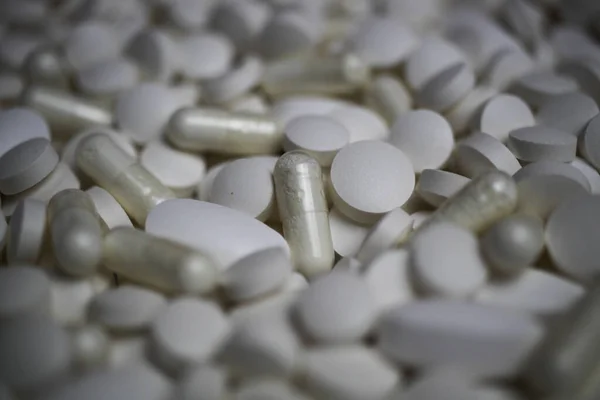 Full frame closeup of pile countless white pills and capsules